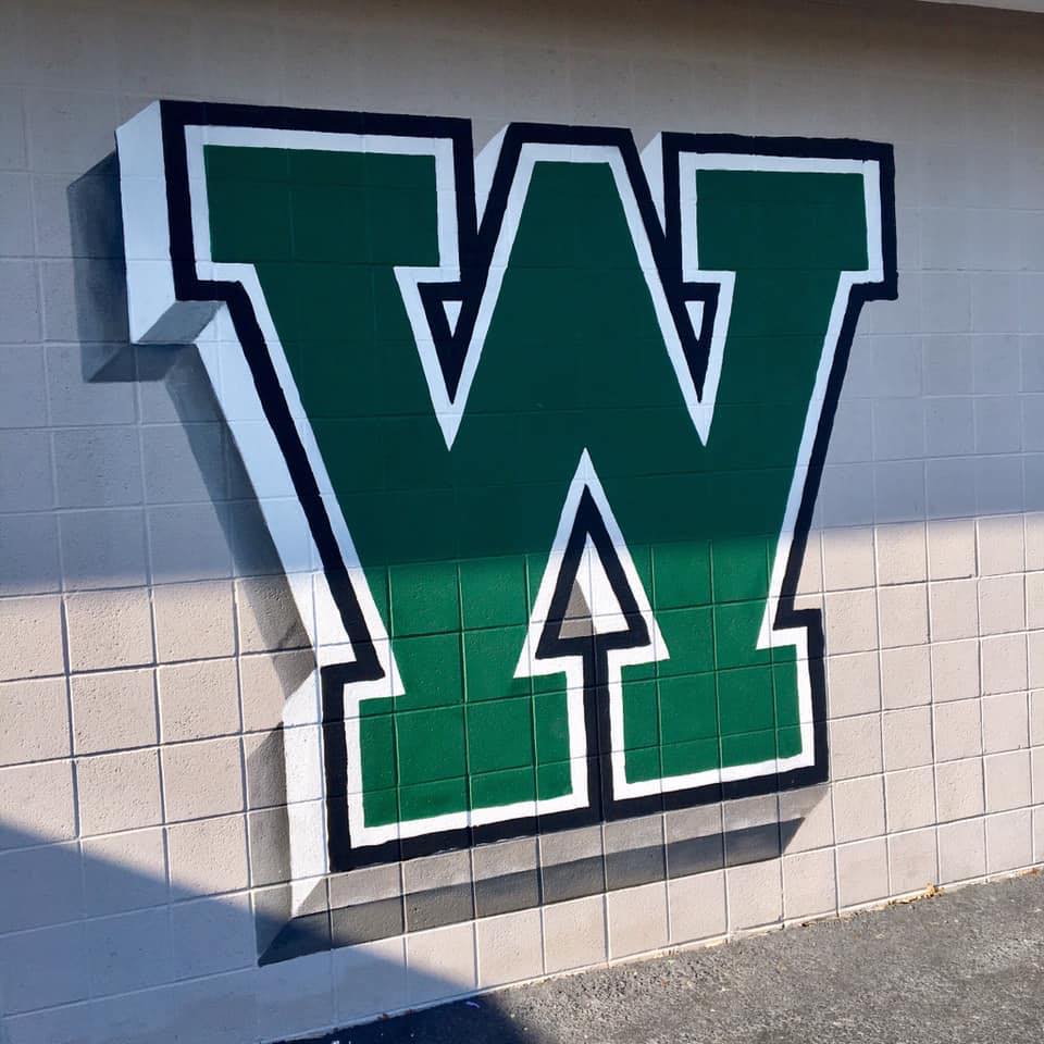 A green W painted on a tile wall.